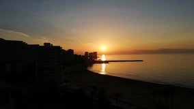 A beautiful sunrise in the Mediterranean sea. The light of sun reflects in the water and creating intense colors. The video was shot in the touristic town of Cullera, in Valencia, Spain, Europe.