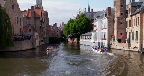 Bruges, Belgium - August 27 2018: Tourists boats on the canals in Bruges on a beautiful summer day