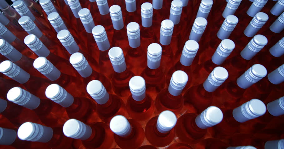 Detail of group of pink wine bottles in metal bascket. Storage stage ready for send away. Beverage production industry. Camera starting with close up, ends with general view. Mendoza, Argetnina