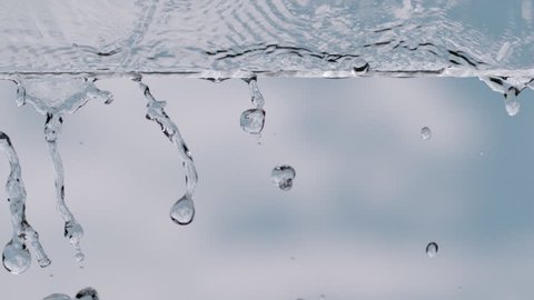 slow motion drops and water on a glass