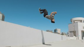 Slow motion parkour athlete doing extreme backflip off wall in urban city outside isolated in sky - Powered by Shutterstock - Get 15% off with code: PIKWIZARD15