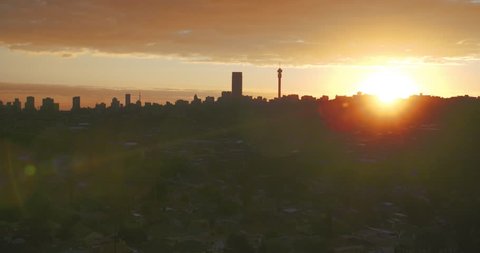 Wide vista of Johannesburg city with slow moving clouds and beautiful African sunset.