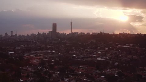 Dramatic clouds and sun beams over the city of Johannesburg in South Africa as the sun sets.