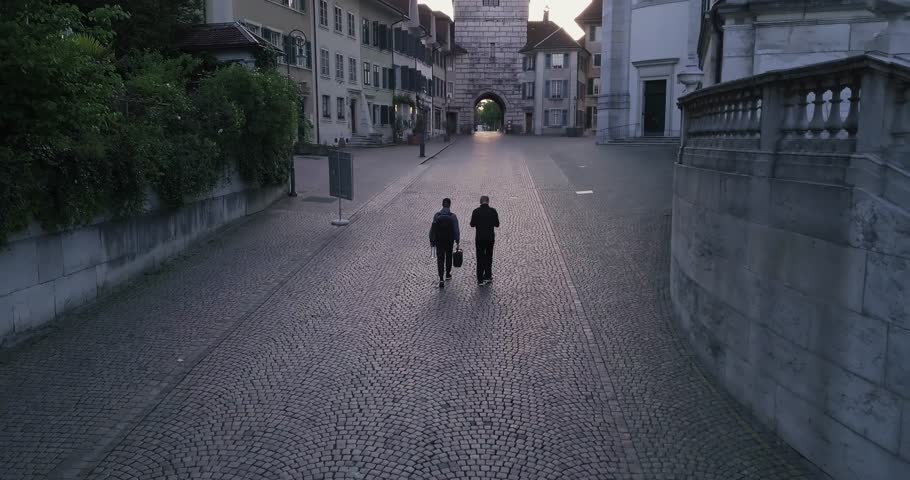 Walking in front of a sunrise in an old empty city.