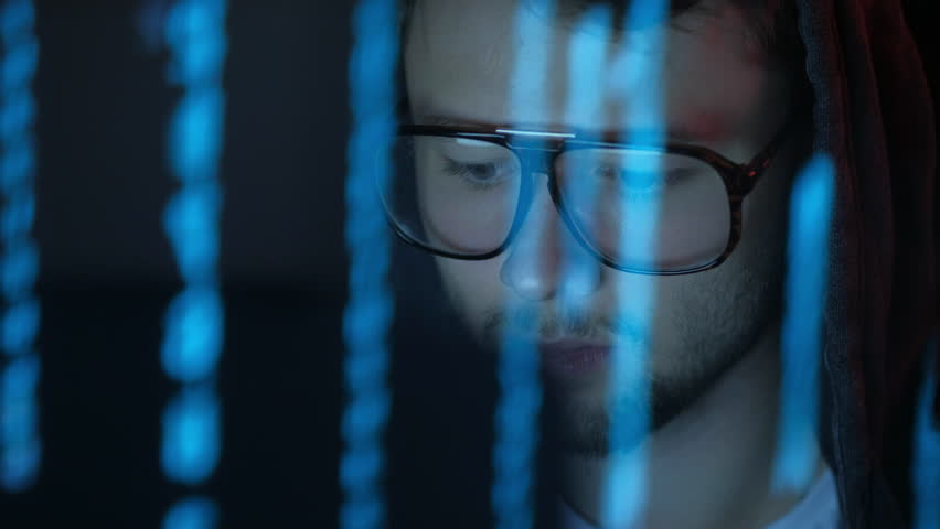The programmer in glasses works at the computer over the program in a dark room night. Smooth blue illumination. Reflection in glasses. ProRes 422 Royalty-Free Stock Footage #1016651947
