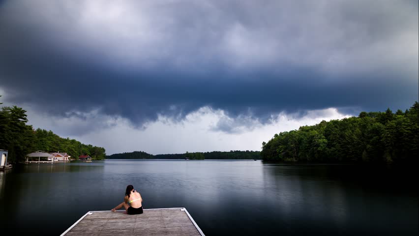 Dark cumulus storm clouds approaching a cottage dock on Lake Joseph, Ontario.