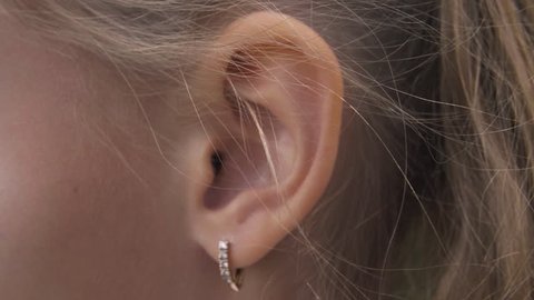 Female ear with earring close up. Ear of woman blonde with decorative piercing