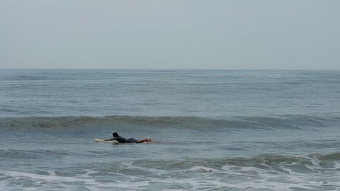 Beach Haven, New Jersey / United States - 06 20 2017: A surfer heading out to the waves.