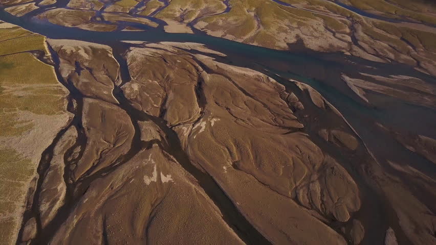 Aerial shot of valley in Canada with Rocky mountains around and river next to road