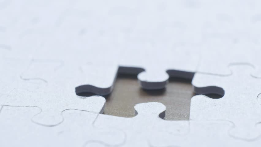 A man putting the last piece of the jigsaw into place