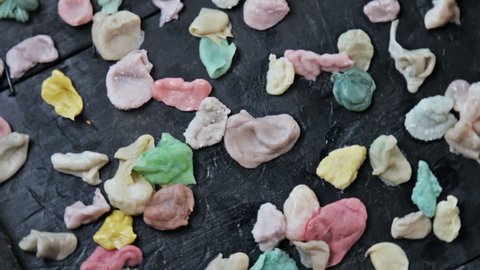 chewed chewing gum of different colors on a black background. VIDEO rotation