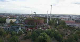 4K summer morning aerial video of Helsinki Linnanmaki amusement park structures, buildings and area around it, green park near railway lines in the capital of Finland Suomi, northern Europe
