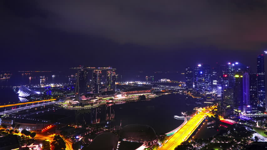 Amazing zooming out time lapse of night cityscape with buildings of Marina Bay Sands hotel, Esplanade Theatre on the Bay and Fullerton Hotel Futuristic view of cars moving on bridge over river