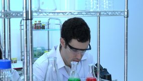 Scientist is looking through microscope with colleagues working in modern laboratory or medical center. Concept of science, testing development and lab industry.