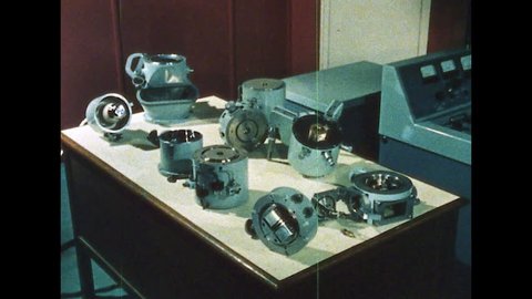 1960s: UNITED STATES: man takes modern electron microscope apart. Cathode and anode by anode plate. Condenser lens on microscope
