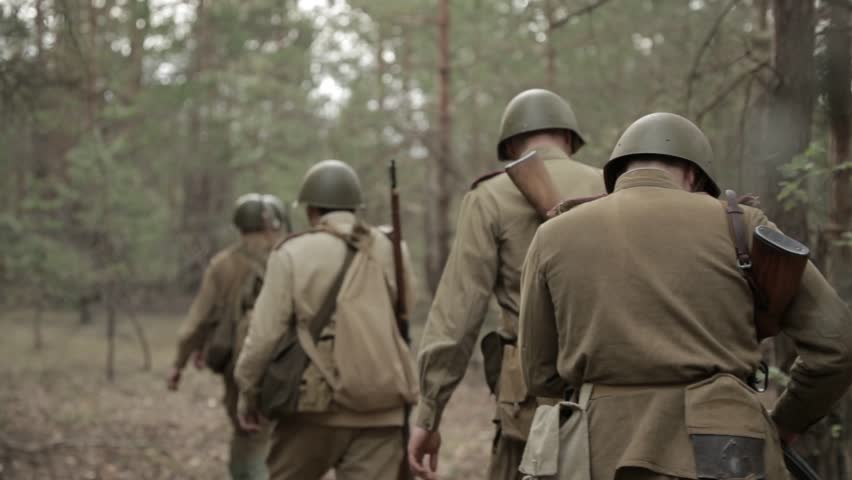 Russian Soviet Infantry Red Army Soldiers Of World War II Marching Walking Along Forest Road In Summer Day. Group of Soldiers Marching In Forest