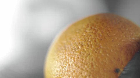 Removing of orange peel from the orange with a knife. Citrus zester grating peeling orange peel, oils spraying.