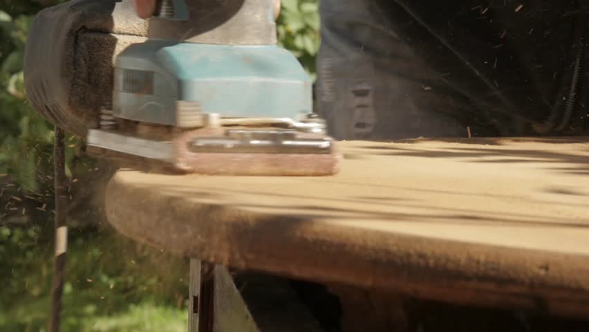 carpenter restoring old furniture, grinding of old wooden countertop. slow motion