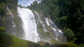 Slow motion video of waterfall splashing with rainbow in the morning at countryside in Chiangmai, Thailand