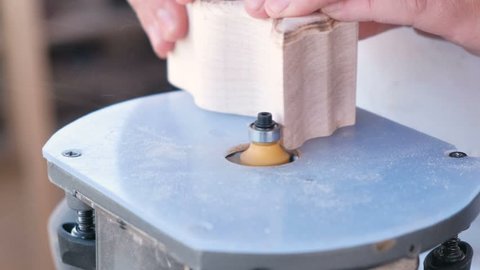 Carpenter make a wooden parts on a manual milling machine. Close-up hands.
