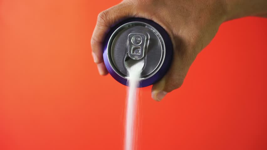 Hand holding soda can pouring lots of sugar in metaphor of sugar content of a refresh drink in unhealthy nutrition, diet, sweet and carbonated drinks addiction and unhealthy food concept red backgroun | Shutterstock HD Video #1016728300