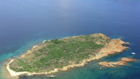 View from above, aerial view of a beautiful small island sorrounded by a transparent and emerald sea, Sardinia, Italy.