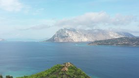 Video from above, amazing aerial view of the Tavolara Island bathed by a turquoise and transparent sea, Sardinia, Italy.