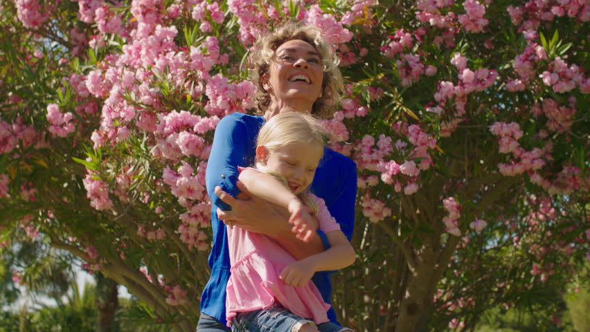 Grandmother and granddaughter in park twirling around