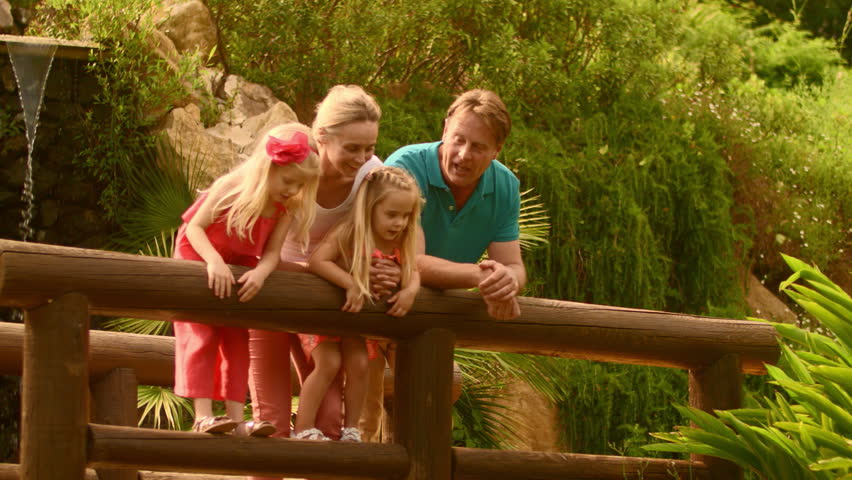 Grandparents and granddaughters standing on bridge in park