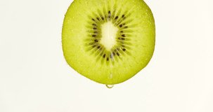 water or oils dropping on a kiwi slice , fruit for diet and healthy food