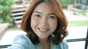 Attractive beautiful happy Asian women blogger using smartphone for selfie and recording making food vlog video for her subscribers and her channel at cafe and restaurant.