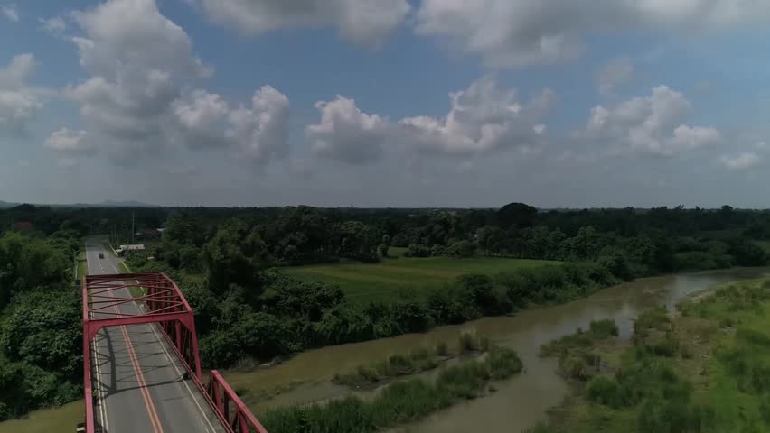 Aerial drone view of a bridge connecting communities along a river stream of Agno River in Pangasinan.