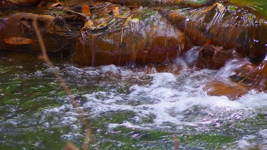 water flowing in stream at weir. sunlight shine under the shade 