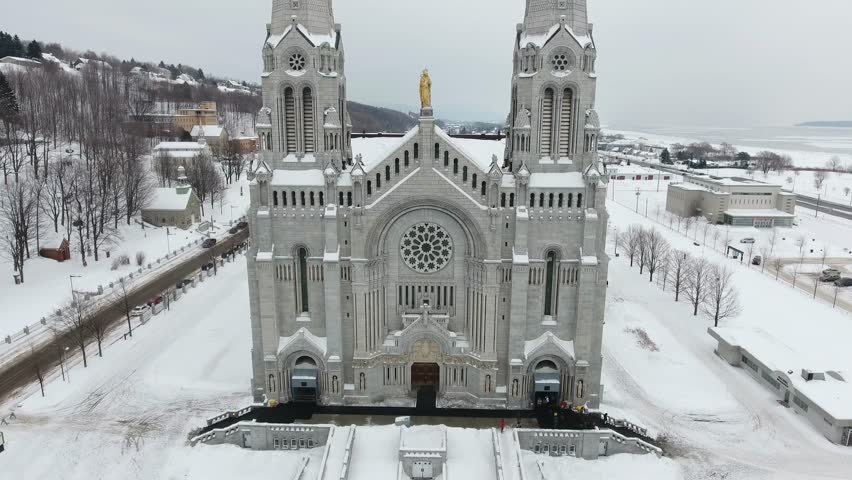 Big church near the St.Lawrence River in Canada, Quebec. Filmed in drone during a winter cloudy day.
