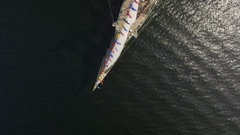 Beautiful Tall Historical wooden Sailing vessel Ship Flutter wind flags. Open ocean sea dark water. Race sport regatta Cruise Graphic abstract. Travel. Russia Europe Asia. Drone Aerial Top 
