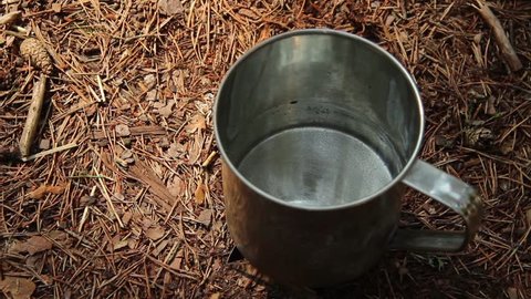 Metal cup warming on fire