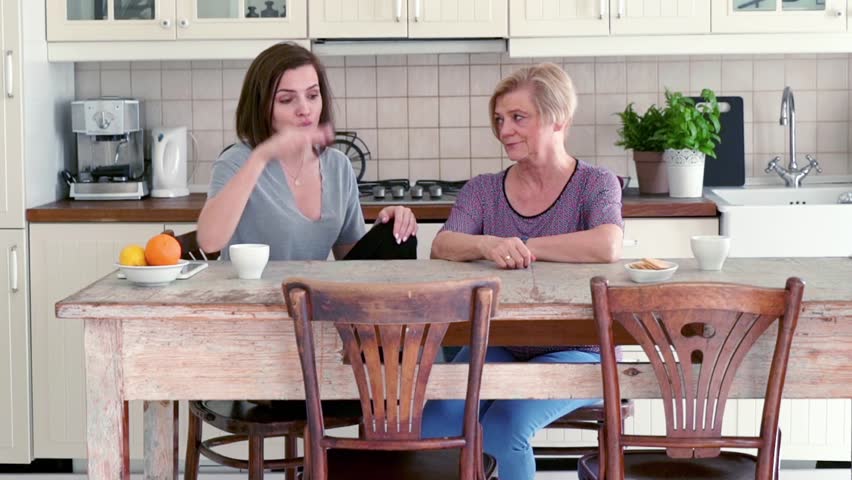 Mother and her adult daughter fighting in the kitchen
