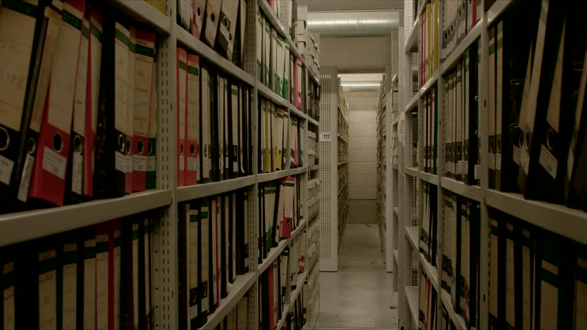In an archive, between two shelf walls, the camera moves through many files
The image can be used for the integration of archive texts in films and reports. Thanks to the 50 frames it can slowed down. Royalty-Free Stock Footage #1016795269