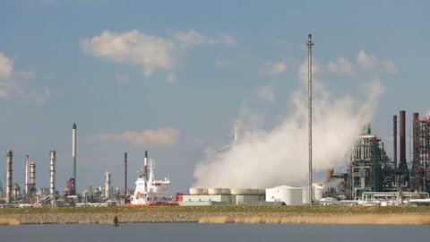 A large steaming industrial complex in the harbor of Antwerp, Belgium with perfect blue sky.
