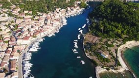 Aerial drone bird's eye view video of iconic small safe port of Gaios with traditional Ionian architecture and sail boats docked, Paxos island, Ionian, Greece