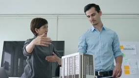 Architects male and Businesswoman are working on a building model. Business woman suggest idea to designer at modern office. concept of construction, architecture, development and creative.