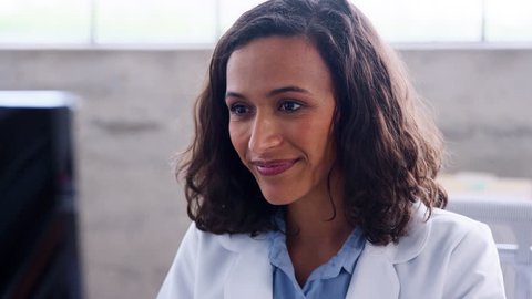 Smiling young female doctor working in an office, close up
