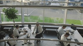 Office workers in white shirts sitting in their workplaces, buried in phones.