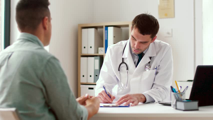medicine, healthcare and people concept - doctor giving prescription for male patient at clinic