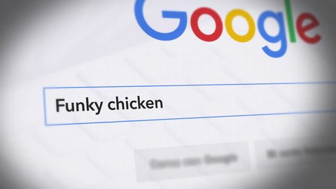 USA-Popular searches in 2018 Google Search Engine - Search For funky chicken - Monitor with reflection hands typing a search on google