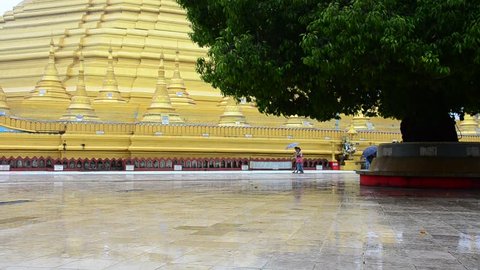 People hold umbrella walking around Shwemawdaw Paya Pagoda at raining time in Bago, Myanmar