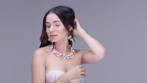 Beautiful woman posing in studio. She shows women's jewelry