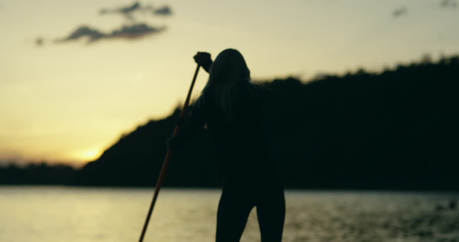 Young woman on a stand up paddle board exercising at sunset on a lake in Sweden. Slow motion and silhouette looking imagery. | Shutterstock HD Video #1016818207