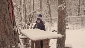 Girl playing in the winter forest. Tall tree. Joyful mood. Walk in the fresh air. Weekend. 4K video.