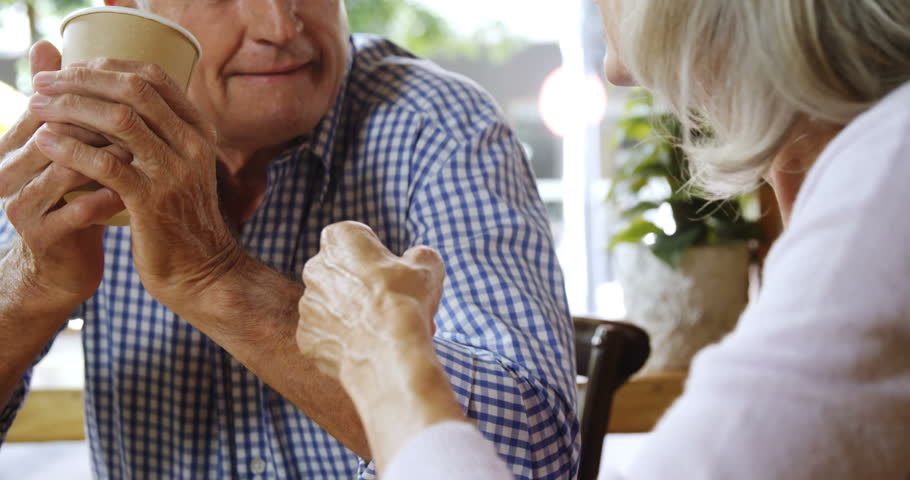 Close-up of Caucasian senior couple talking while having coffee in the cafe 4k
